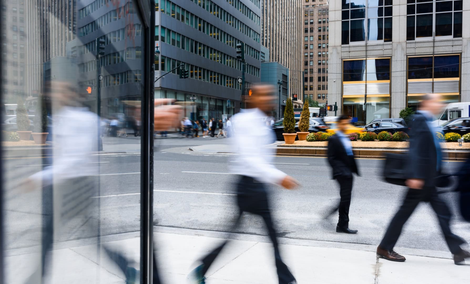 Reflections of businesspeople walking in Chicago city street.