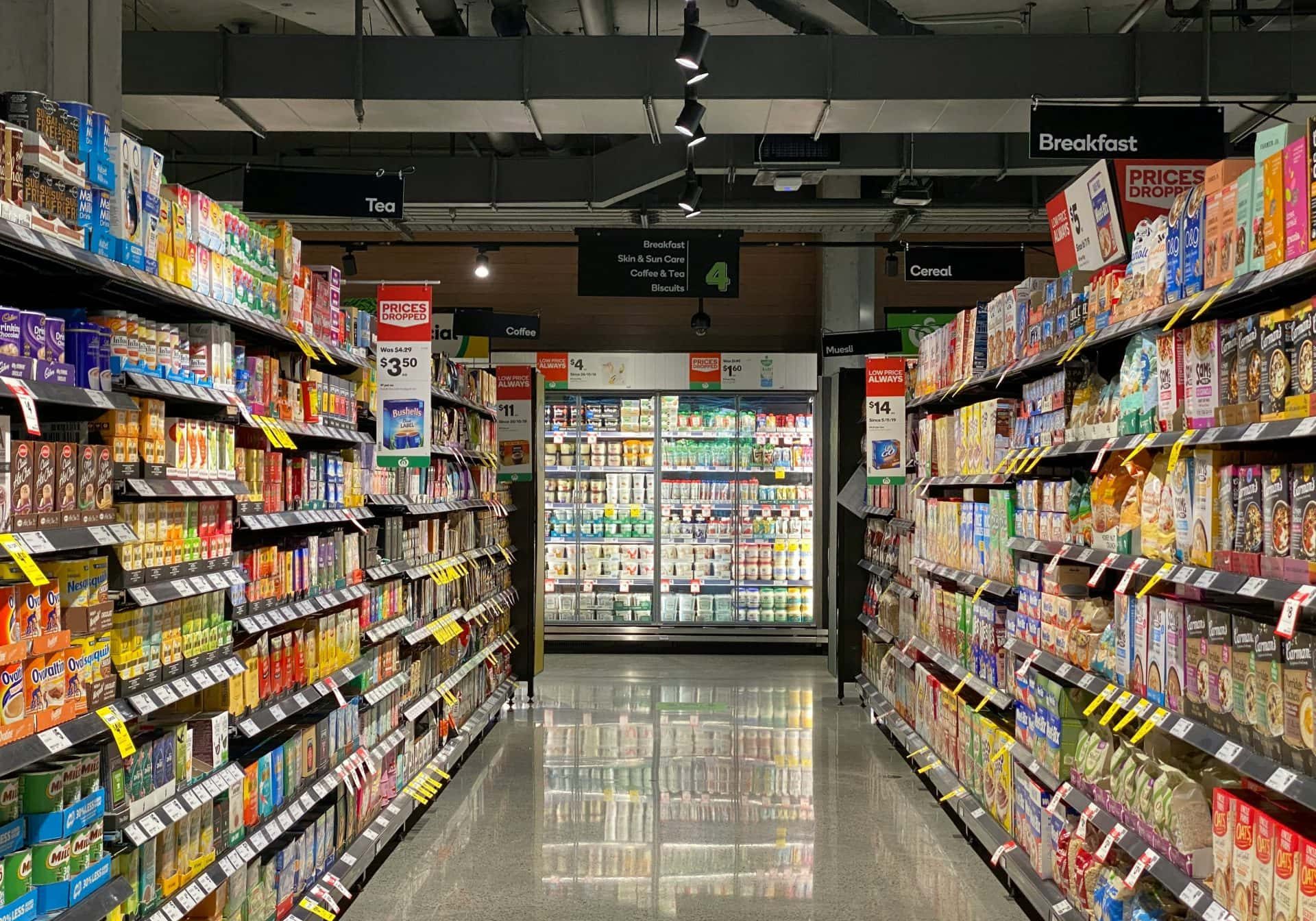 Brightly lit grocery store aisle featuring cereal, snacks, and dairy products on organized shelves.